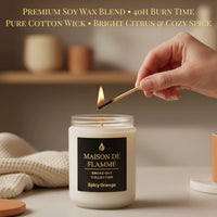 Thumbnail for Hand lighting the Maison De Flamme Spicy Orange candle on a table — warm citrus aroma and cozy home fragrance.