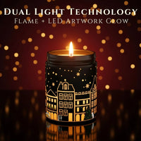 Thumbnail for Dual Light Technology showing real flame and LED artwork glow on a Black Jar. Black Cherry candle – winter village design illuminated, available at Shopeezy.