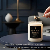 Thumbnail for Hand lighting the Maison De Flamme White Musk candle on a dark navy background — soft clean musk home fragrance.