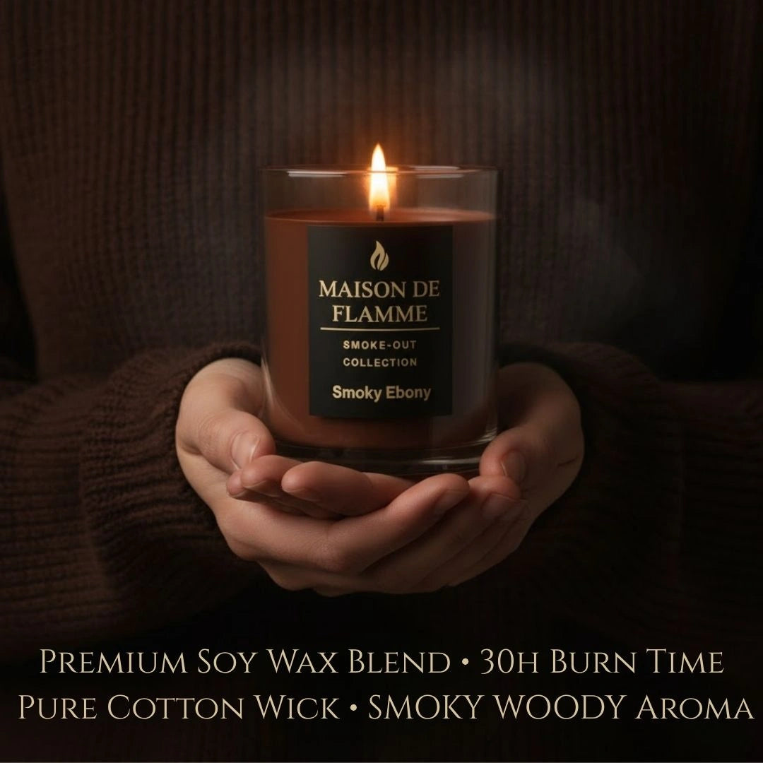 Smoky Ebony candle held in cozy hands, warm smoky woody aroma aesthetic.