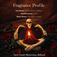 Thumbnail for Skeleton novelty candle with blackcurrant, saffron, rose, patchouli and amber fragrance notes displayed, dark floral Halloween scented candle in red wax skull holder