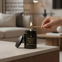 Thumbnail for Hand lighting the black Jasmine & Sandalwood candle on a modern wooden table — soft floral and woody home fragrance.