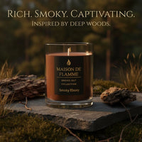 Thumbnail for Smoky Ebony candle on forest stone with moss and pine needles, rich smoky captivating woodsy scent.