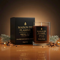 Thumbnail for Smoky Ebony candle with box in warm golden studio setup with pine needles and wood elements.